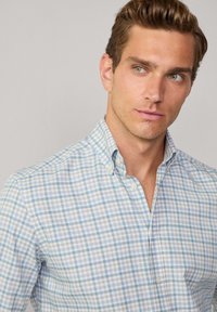 Light blue and white checkered shirt with a button-down collar, featuring a soft cotton texture and a relaxed fit.