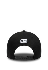Casquette de baseball noire avec visière plate, sangle ajustable à l'arrière, et logo MLB brodé en blanc à l'arrière.