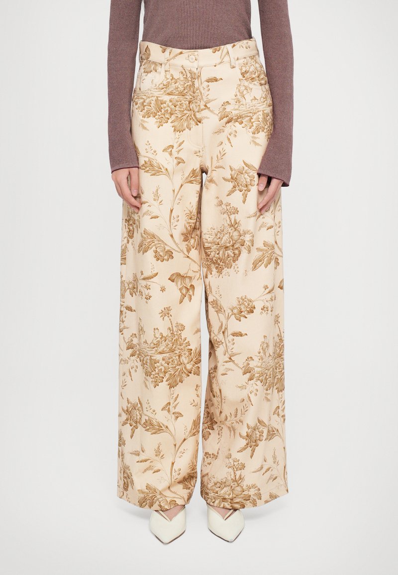 Pantalons à large jambe en tissu beige, ornés d'un motif floral brun. Taille haute avec des poches latérales, finition avec une texture lisse.