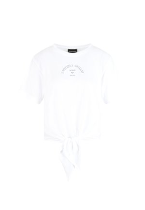 Hvid bomulds T-shirt med rund halsudskæring, korte ærmer og en frontknude-detajle. Har et trykt logo i grå over knuden.