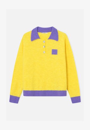 Keltainen neulepaita, jossa on violetti kaulus, kalvosimet, helma ja rintatasku, ja kolme nappia etumuksessa.