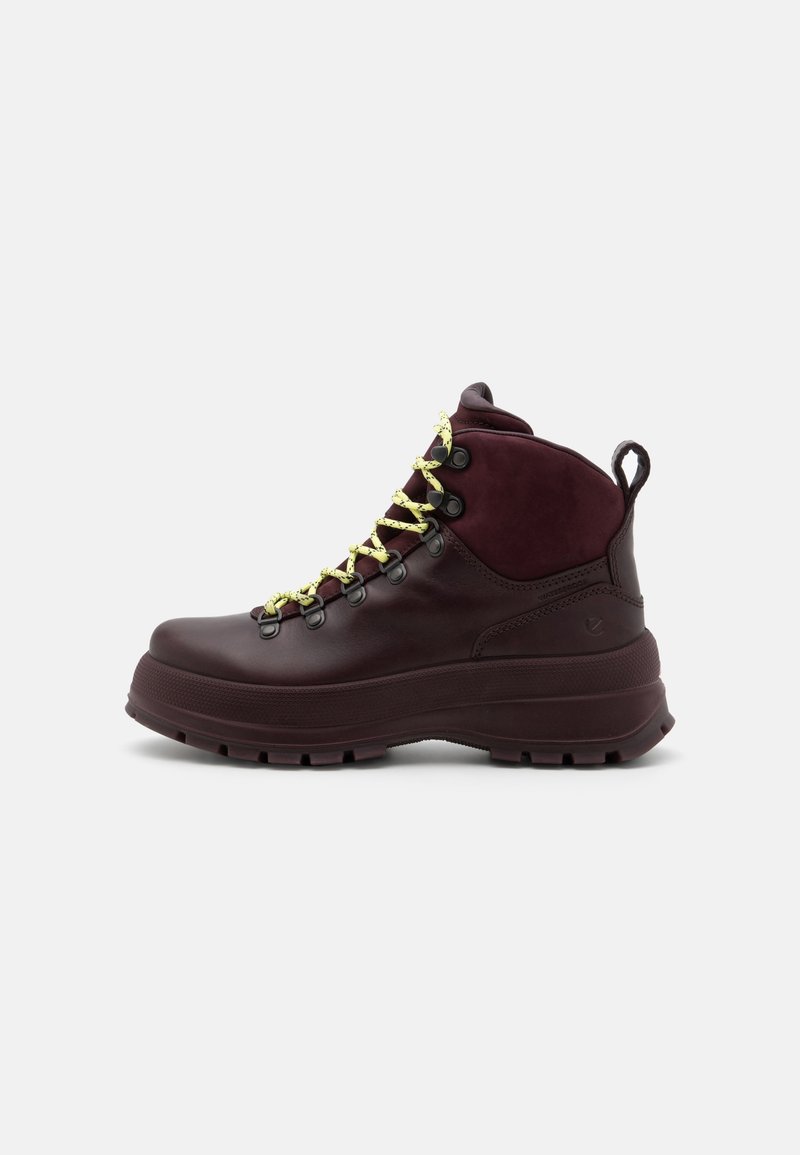 Donkerburgundy wandelschoenen met een glanzende leren afwerking, voorzien van gele veters, metalen oogjes en een robuuste zooltextuur.