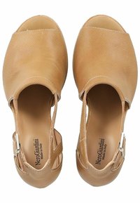 Beige leather sandals with open toe design, perforated texture, and side zipper closure. Features cut-out details and a smooth inner lining.
