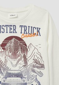 Weißes Langarmhemd mit Grafik von zwei Dinosauriern und einem Truck, mit lila und orangen Drucken sowie Bergen im Hintergrund.
