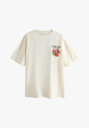 Cremefarbenes T-Shirt mit kurzen Ärmeln, floralem Design und dem Text "Mahalo Kailua-Kona" auf der linken Brust.