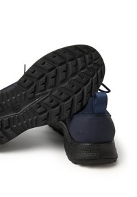Zapatos deportivos de color azul marino con suela exterior de goma negra texturizada y un patrón de tracción, parte superior de malla con una lengüeta en el talón para un uso fácil.