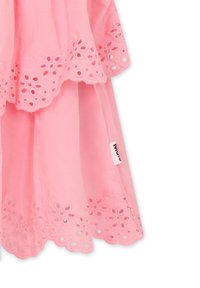 Abito rosa chiaro con bordo in pizzo floreale ricamato e motivi a intaglio sull'orlo. Il tessuto è liscio con una morbida texture.