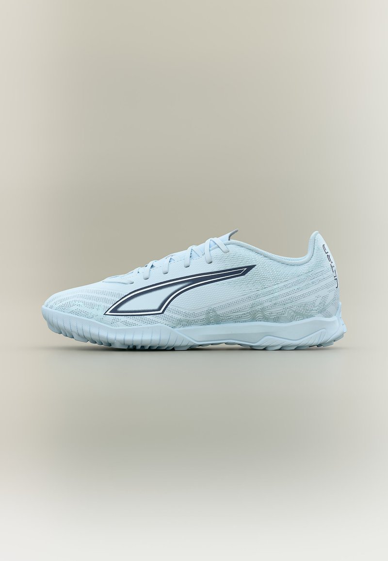 Scarpa da ginnastica azzurro chiaro con suola strutturata, lacci e logo laterale nero a onde, mostrata di profilo su sfondo neutro.