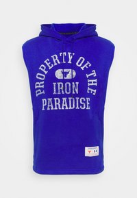 Felpa senza maniche blu in cotone misto, con la scritta "PROPRIETÀ DELL'IRON PARADISE" in bianco sbiadito e un logo. Include tasche frontali.