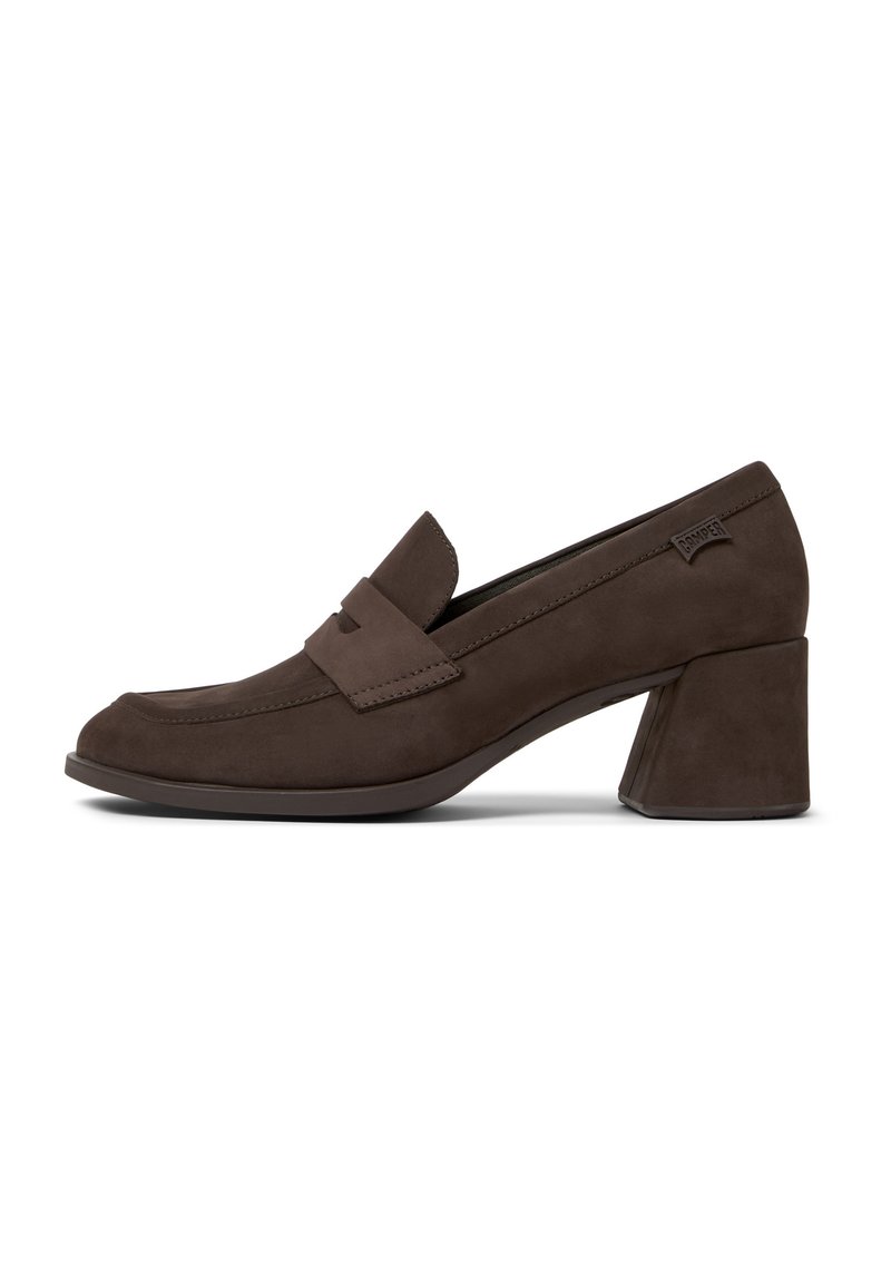 Brown suede loafers with a low block heel, featuring a stitched design and a front strap detail. Smooth texture and rounded toe.