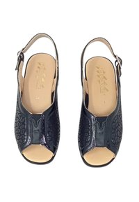 Scarpe slingback nere con tomaia texture e motivo leopardato, design open toe e soletta liscia beige.