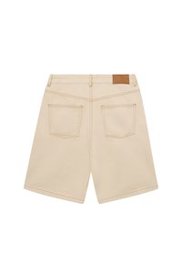 Pantalones cortos de mezclilla beige con corte recto, que presentan dos bolsillos traseros y un parche de cuero marrón en la cintura. Detalles de costura limpia.