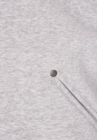 Ljusgrå sweatshirt med subtil textur, dragkedjeförsedd ficka och en liten metallisk logoknapp på sidan.