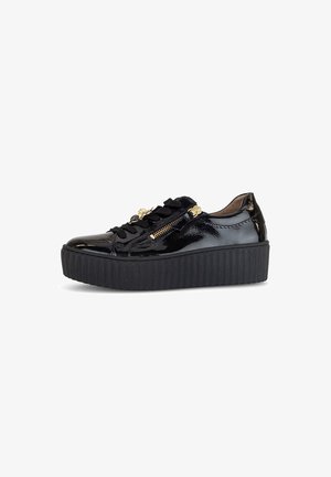 Sneaker in pelle verniciata nera con suola spessa e seghettata, dotate di allacciatura frontale e zip laterale per un dettaglio in più.