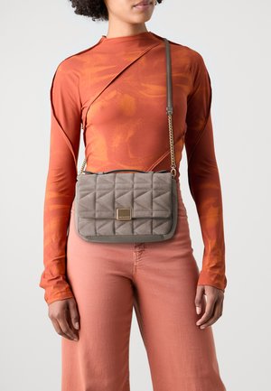 Borsa a spalla grigia trapuntata con un accento dorato e tracolla a catena. Realizzata in materiale morbido, ha una forma rettangolare e una texture liscia.