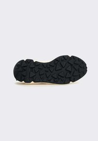 Semelle de chaussure en caoutchouc noir avec une surface texturée comportant des motifs triangulaires et un bord de couleur claire. Adaptée pour l'adhérence et la traction.