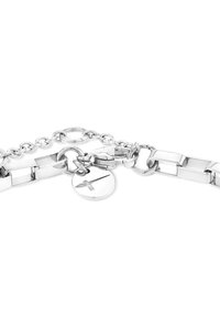 Bracciale in metallo argentato caratterizzato da un mix di maglie allungate e rotonde, una chiusura e un ciondolo circolare con un simbolo di croce inciso.