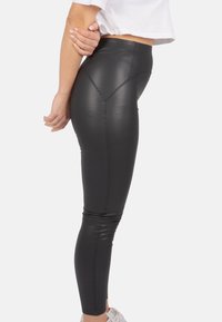 Schwarze Leggings aus Kunstleder mit hoher Taille, glatter Textur und Nahtdetails. Entworfen für eine figurbetonte Silhouette und durchgängige Länge.