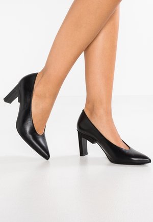 Czarne skórzane buty na wysokim obcasie z zaostrzonym noskiem i masywnym obcasem, z gładką fakturą i minimalistycznym designem.