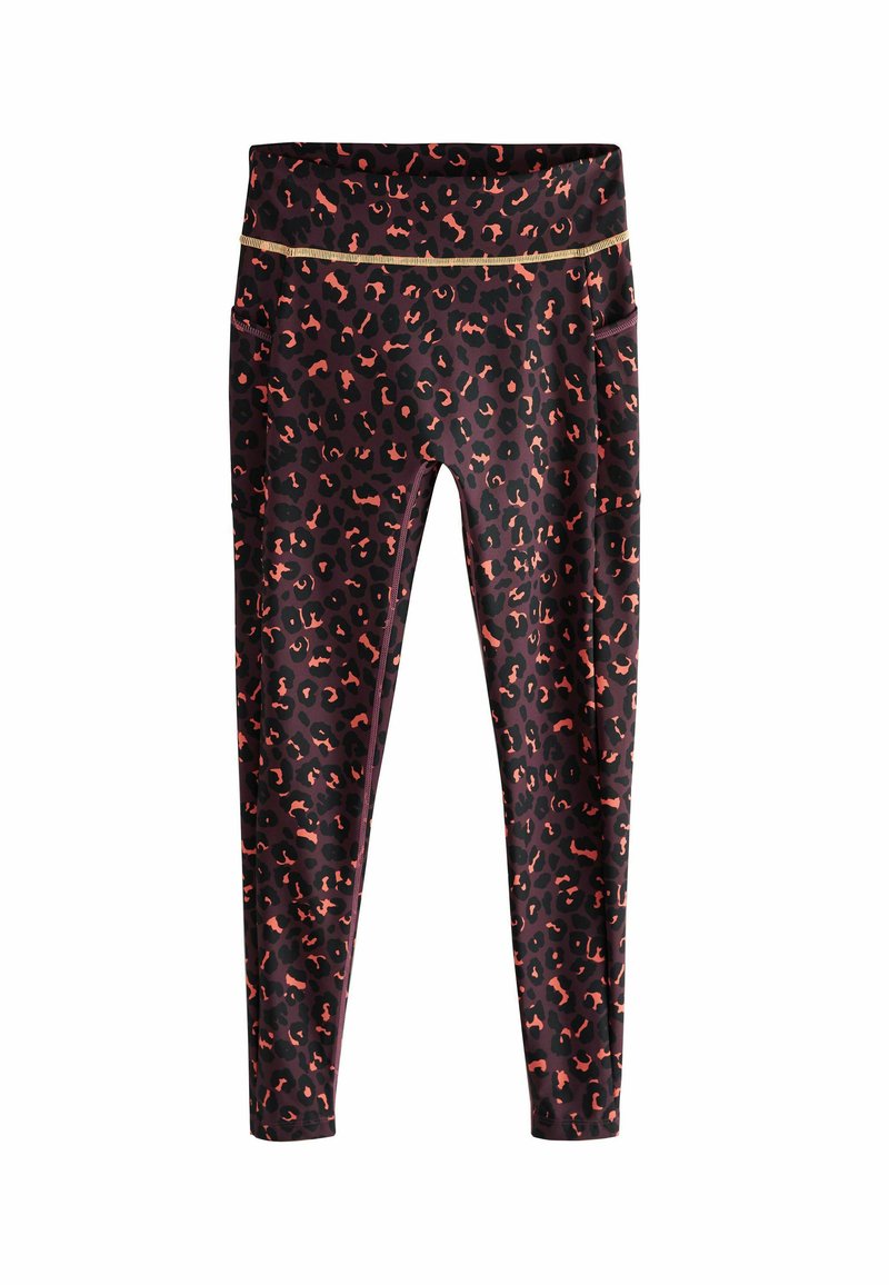Leggings sur un fond sombre avec un imprimé léopard vibrant dans des teintes d'orange et de rose. Présente une taille haute avec un accent doré.