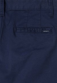 Marineblå shorts laget av bomullsblanding, med en baklomme med sømdetalj og en liten etikett som sier "HACKETT."