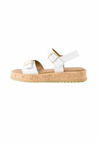 Sandales à plateforme blanches avec deux boucles à sangle réglables, semelle à texture liège et intérieur en cuir lisse. Comprend une semelle extérieure en caoutchouc.