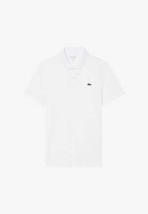 Polo blanco de manga corta con cuello y dos botones, con un pequeño logo de cocodrilo verde en el pecho izquierdo.