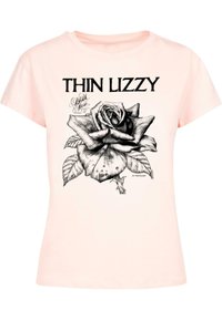 Šviesiai rožinė medvilninė marškinė su juodu grafiniu spausdiniu, vaizduojančiu rožę, su užrašu "THIN LIZZY" viršuje ir dekoratyviniais akcentais po gėle.