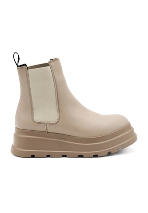 Stivale alla caviglia in pelle beige con pannelli laterali elastici, suola a piattaforma spessa e un tassello per il training. Texture liscia con accenti in tessuto a contrasto.