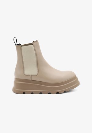 Stivale alla caviglia in pelle beige con pannelli laterali elastici, suola a piattaforma spessa e un tassello per il training. Texture liscia con accenti in tessuto a contrasto.