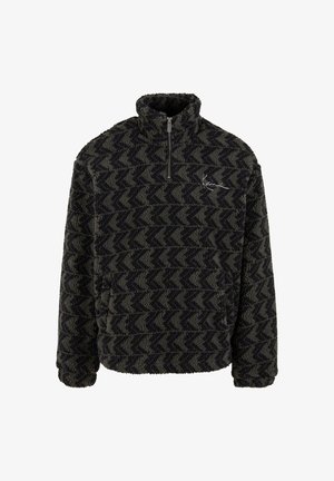 Fluffy pullover in donkergroen en zwart met een zigzagpatroon, halve rits kraag en geborduurd logo op de borst. Getextureerd fleece materiaal.