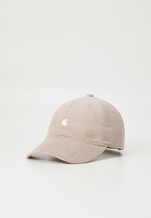 Beige kordfløjl baseballkasket med buet skygge og lille hvidt broderet logo på frontpanelet.