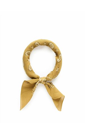 Sennepsgul stof bandana med hvide paisley-print, bundet i en løkke med to ender hængende ned mod en hvid baggrund.