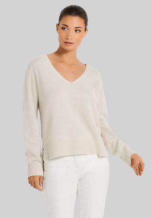 Hellbeige Strickpullover mit V-Ausschnitt, langen Ärmeln und geripptem Saum. Beinhaltet seitliche Schlitze, weiche Textur und lockere Passform.
