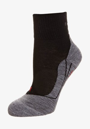 Calcetín negro y gris hasta el tobillo con puño acanalado, puntera reforzada, suela acolchada y logotipo de acento rojo, que presenta una mezcla de materiales texturizados.