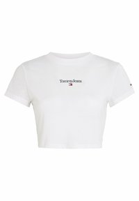 Bílé zkrácené tričko z bavlny s kulatým výstřihem. Na rukávu se nachází černé logo "Tommy Jeans" nad malým červeným a modrým emblémem.