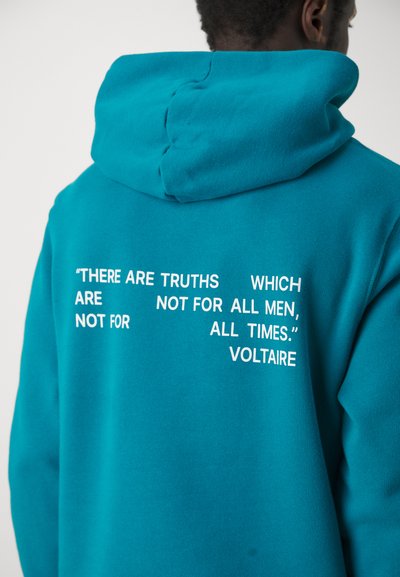 Turquoise hoodie made of soft fabric, featuring white text quotes on the back. The hood is adjustable, and the design is casual and contemporary.