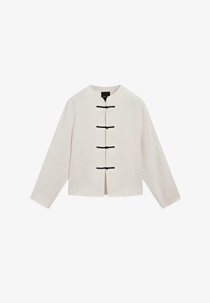 Veste couleur crème avec col Mao et quatre fermetures à bascule horizontales noires sur le devant, manches longues, ourlet droit.