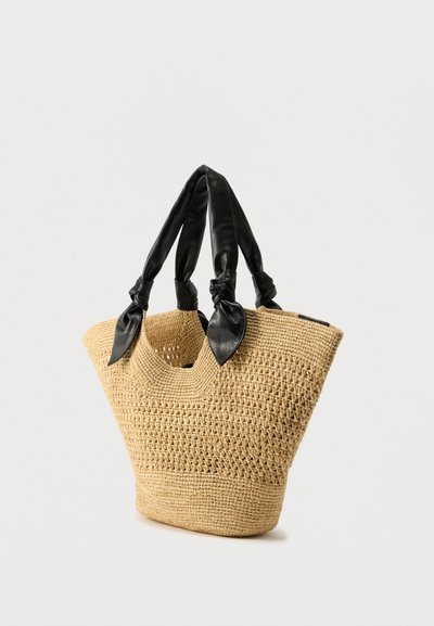 Πλεκτή τσάντα ώμου από ψάθα σε ταμπά χρώμα με μαύρες δερμάτινες χειρολαβές δεμένες σε κόμπο. Διαθέτει ανοιχτό πάνω μέρος και δομημένο, γωνιώδες σχήμα.
