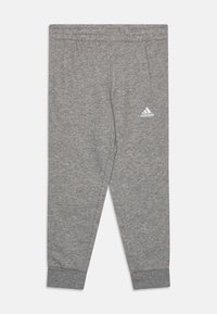 Pantalones de chándal grises, hechos de una tela suave, con una cinturilla elástica, perneras ajustadas y un pequeño logo blanco de Adidas en el lado izquierdo.