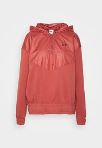 Červená mikina s kapucí, s texturovaným lesklým panelem na hrudi, pulovrový design a elastické manžety. Obsahuje zipový otvor na krku a nastavitelnou kapuci.