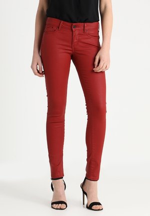 Jeans ajustados rojos fabricados con una mezcla de algodón, que presentan un diseño clásico de cinco bolsillos, cierre de cremallera y botón. Textura suave con un ligero brillo.