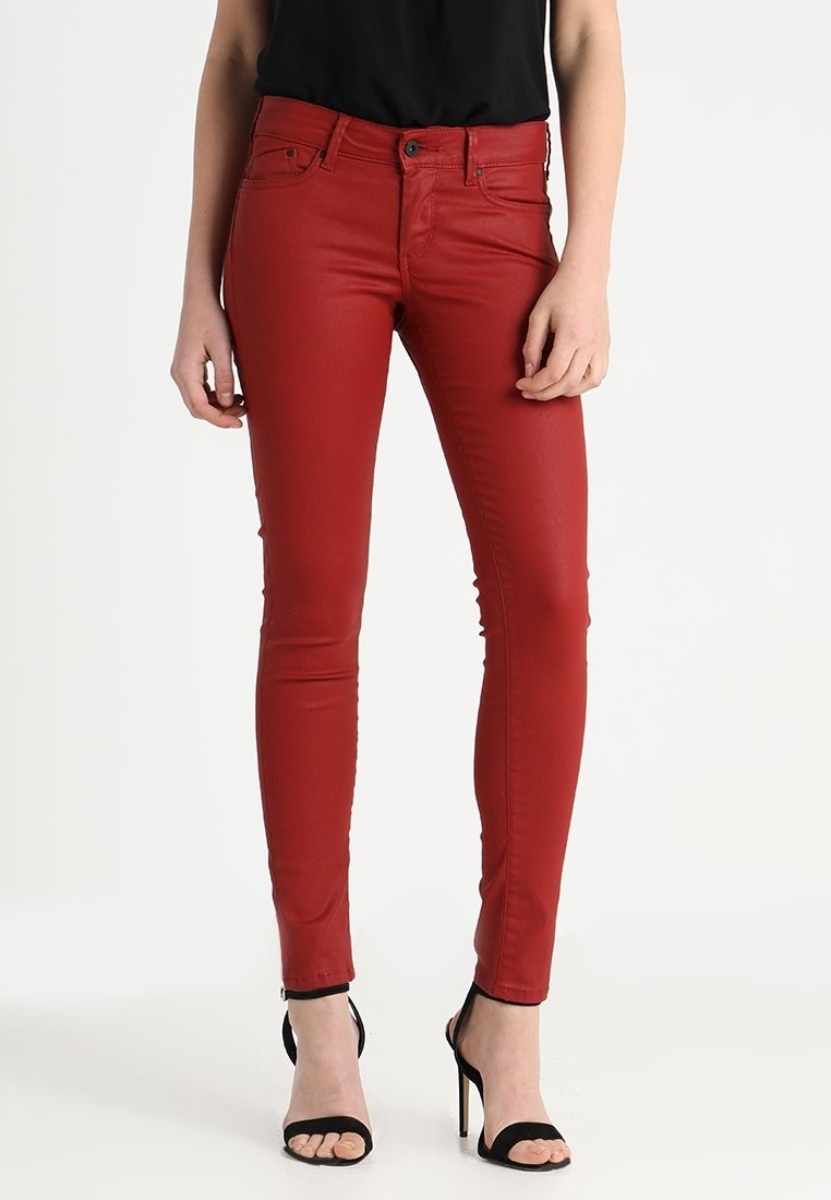 Jeans ajustados rojos fabricados con una mezcla de algodón, que presentan un diseño clásico de cinco bolsillos, cierre de cremallera y botón. Textura suave con un ligero brillo.
