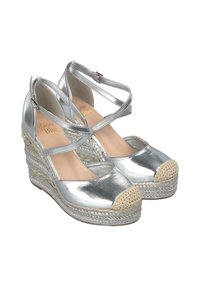 Scarpe a zeppa metallizzate argento con cinghie alla caviglia e punta aperta. Presentano una soletta in juta intrecciata e una punta beige testurizzata.