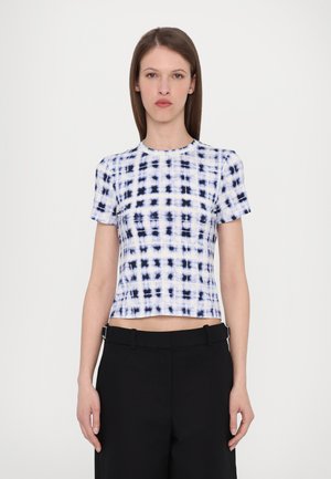 Kortermet crop top i hvit og marineblå tie-dye mønster. Laget av jevnt stoff med rund hals og tettsittende design. Kombineres med svarte bukser.