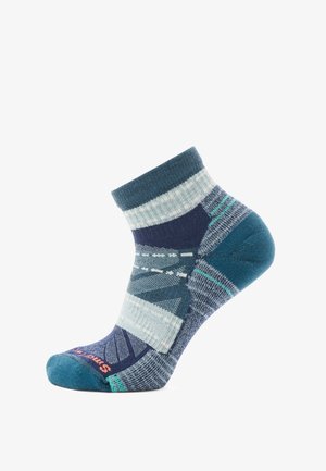 Enkelsok in tinten blauw en teal, met geometrische patronen, ribgebreide boord en contrasterende teen. Zacht materiaal, ontwerp met gestreepte meerdere maten.