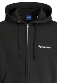 Schwarze Zip-Hoodie aus Baumwolle, mit einem Kordelzug in der Kapuze, Vordertaschen und gesticktem "Original Studio"-Logo auf der Brust.