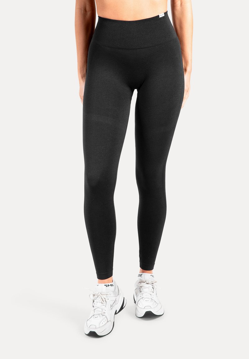 Schwarze Leggings mit hoher Taille aus dehnbarem, glattem Stoff. Verfügen über einen breiten Bund und eine eng anliegende Silhouette.
