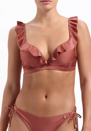 Bikini rose avec des bretelles à volants, un décolleté en V plongeant et un bas de bikini à nouer sur le côté, réglable, avec des accents en métal doré.