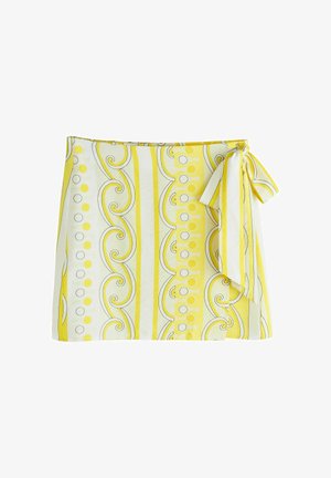 Kollane ja valge mähiskleit vertikaalsete triipude, keerutuste ja täppidega, paremal küljel vibus kinni seotud